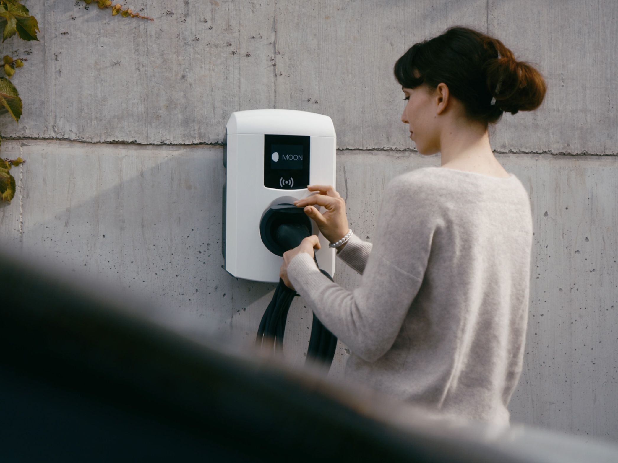 Osoba priključuje kabel u zidnu kutiju