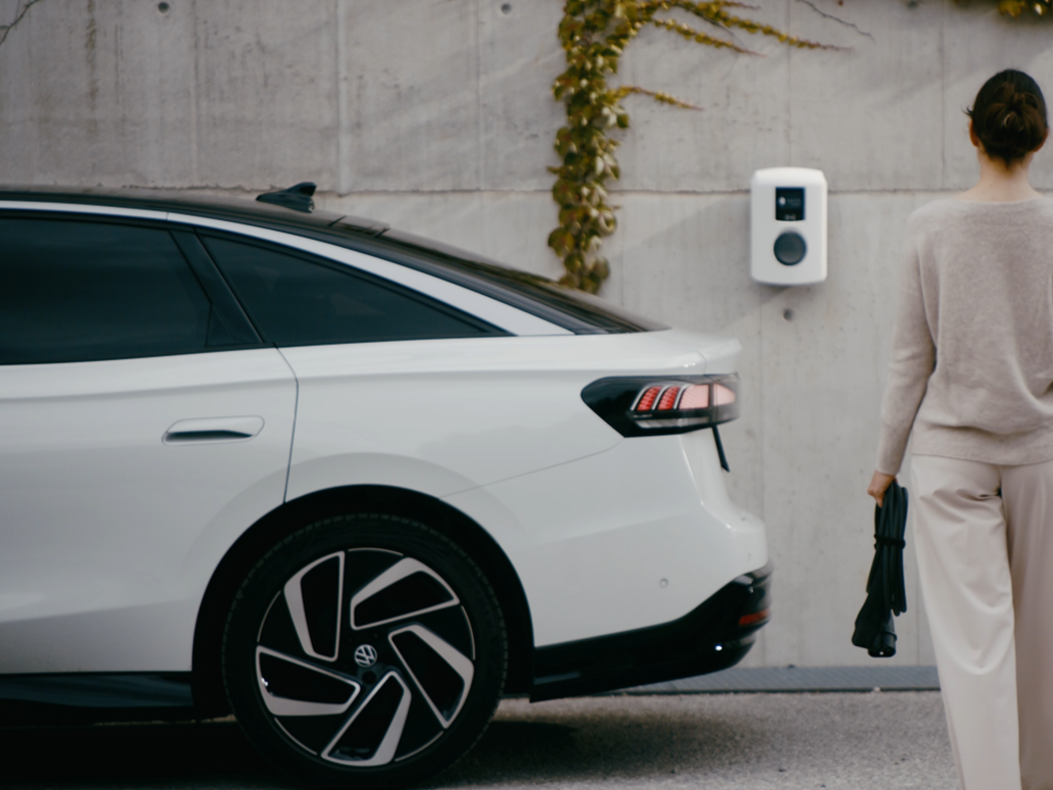 Žena hoda prema stanici za punjenje na zidu