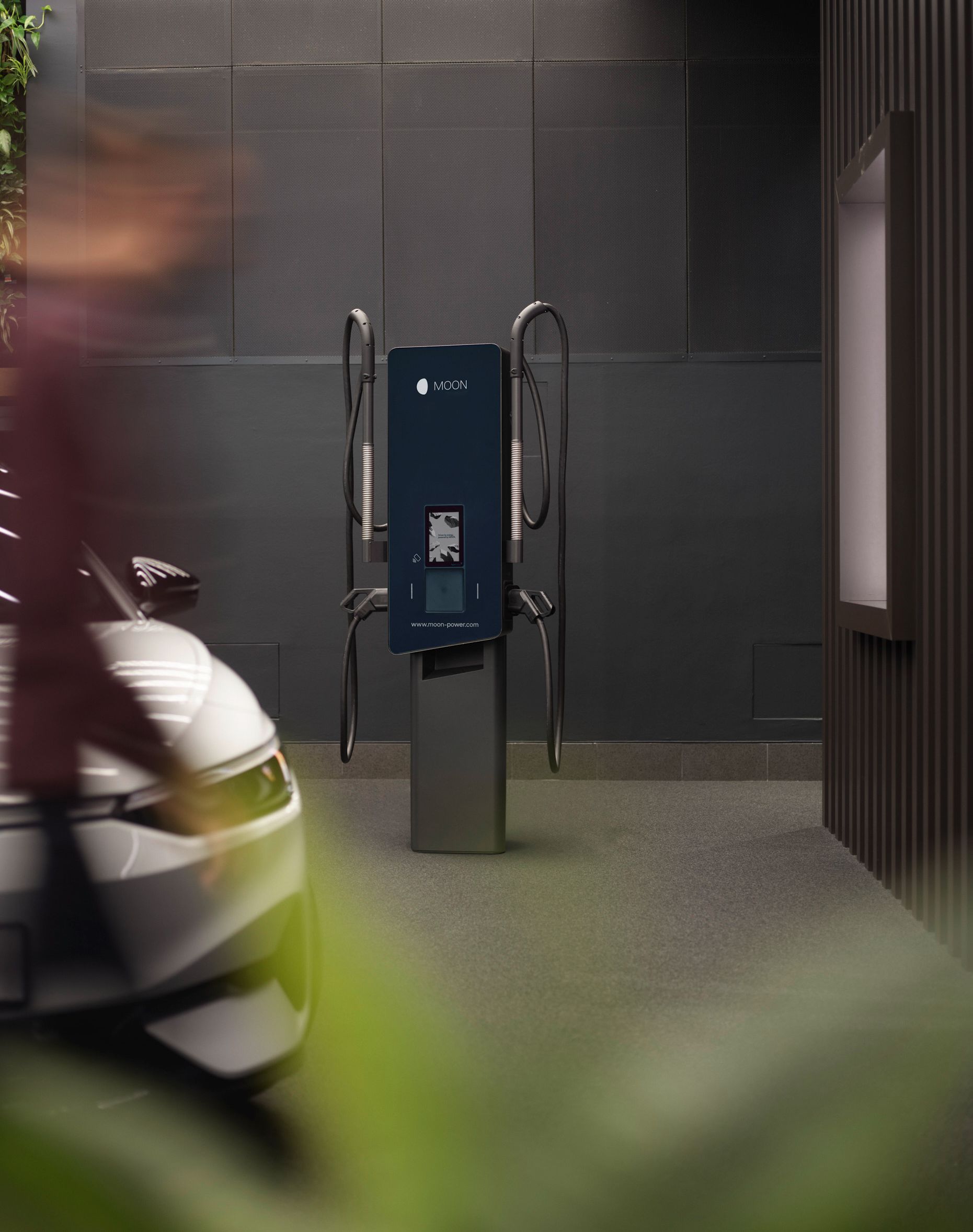 Punionica ispred sivog zida s automobilom u prvom planu