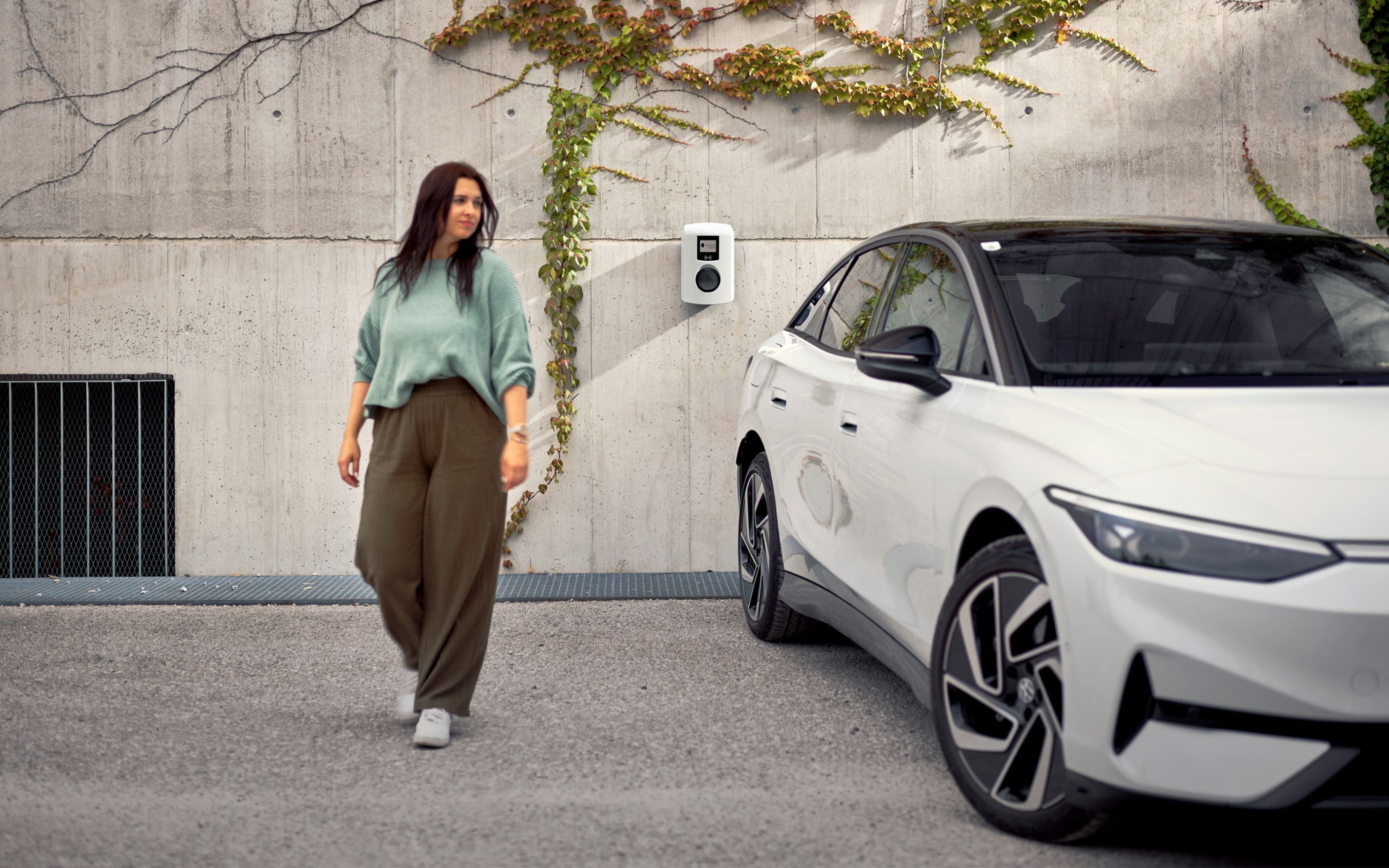 Žena hoda pored bijelog auta