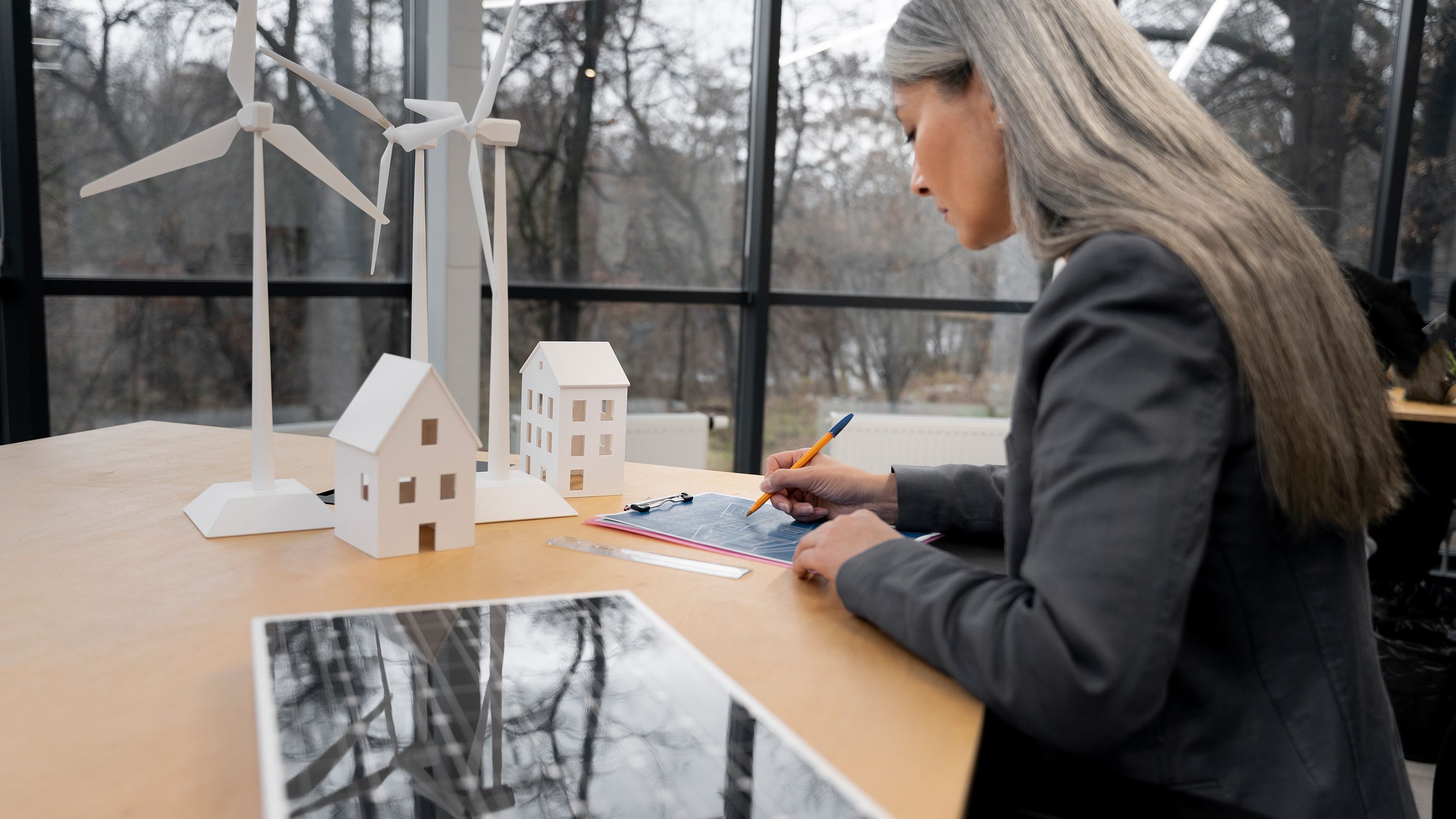 Žena stoji za stolom i nešto zapisuje