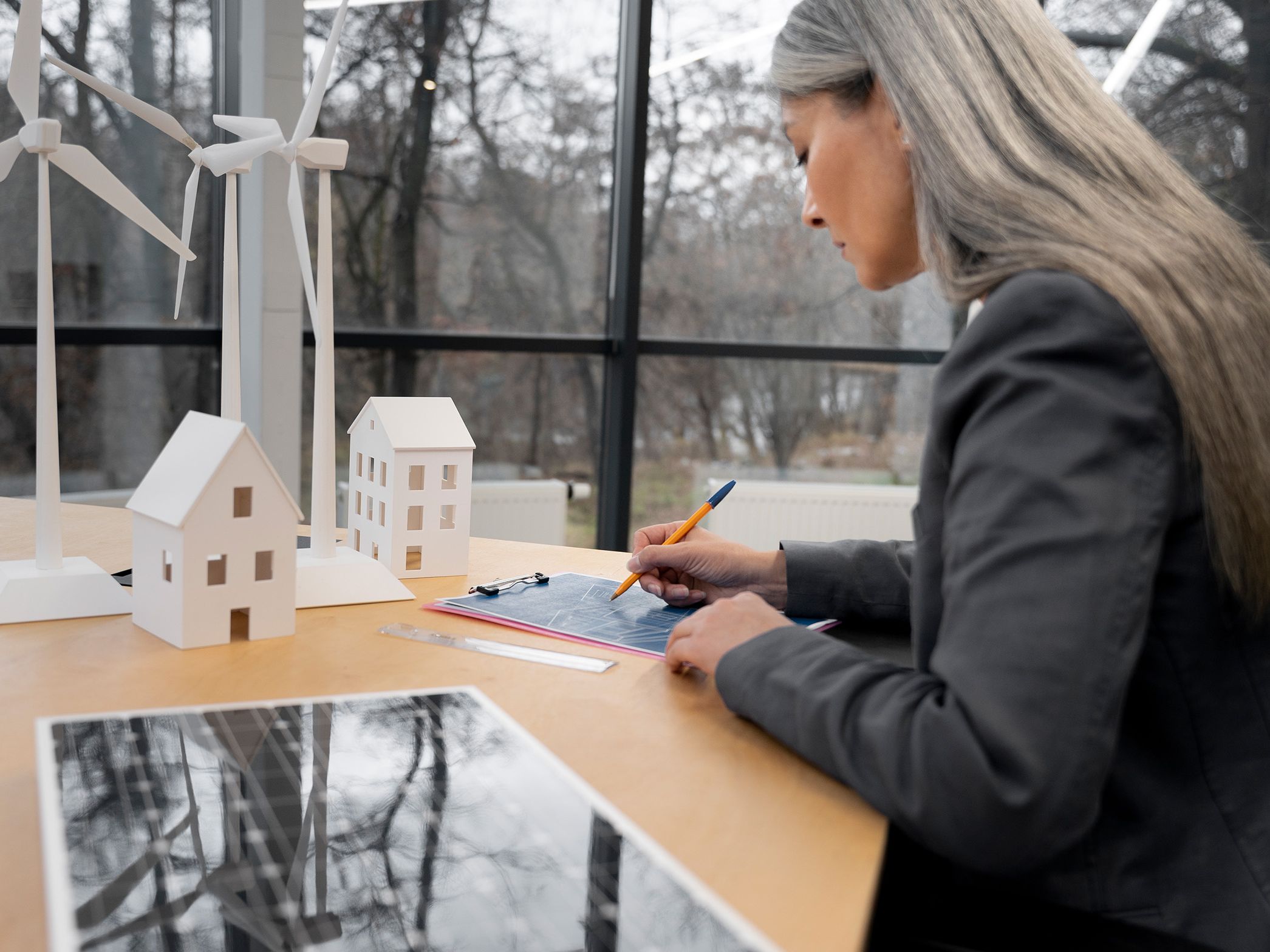 Žena stoji za stolom i nešto zapisuje