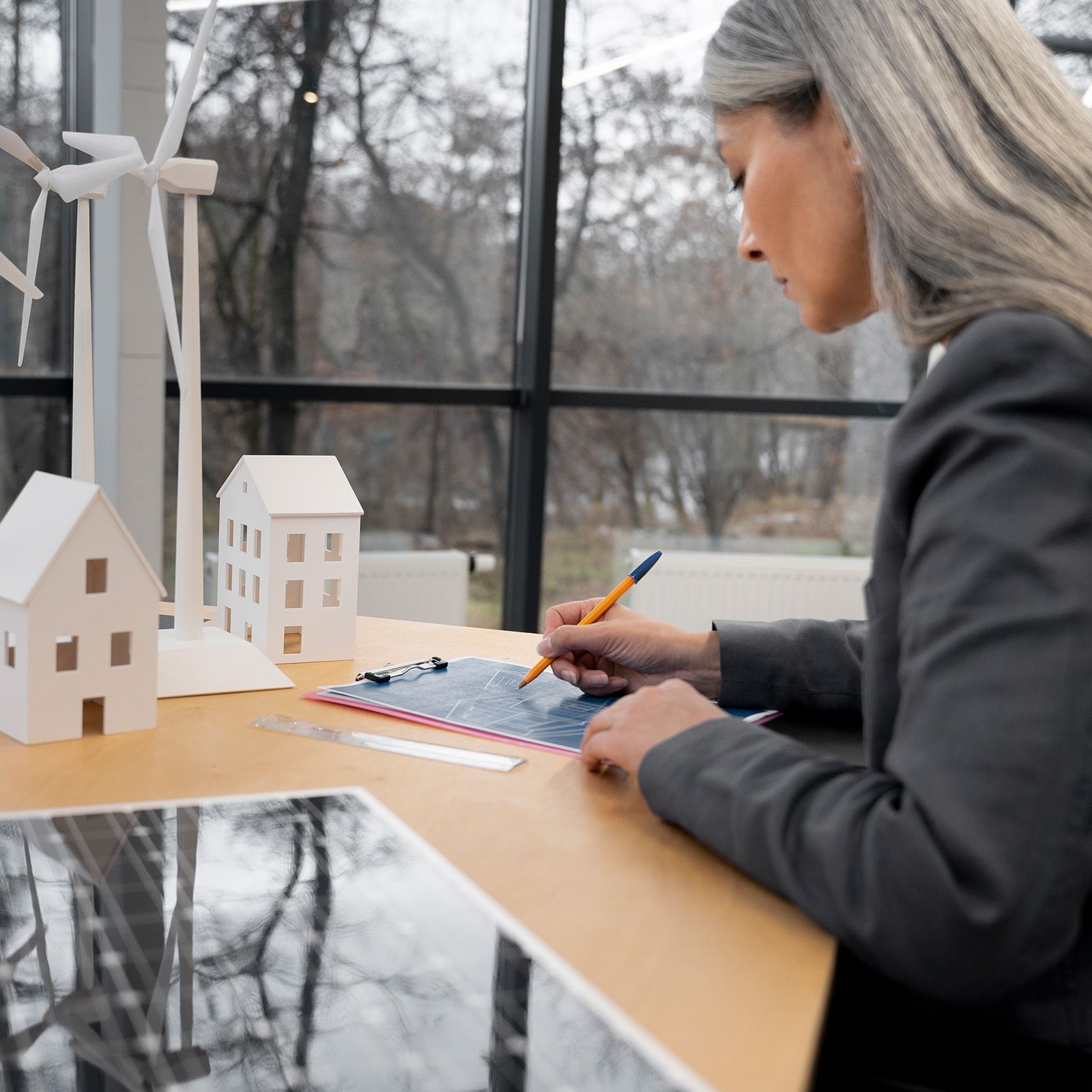 Žena stoji za stolom i nešto zapisuje