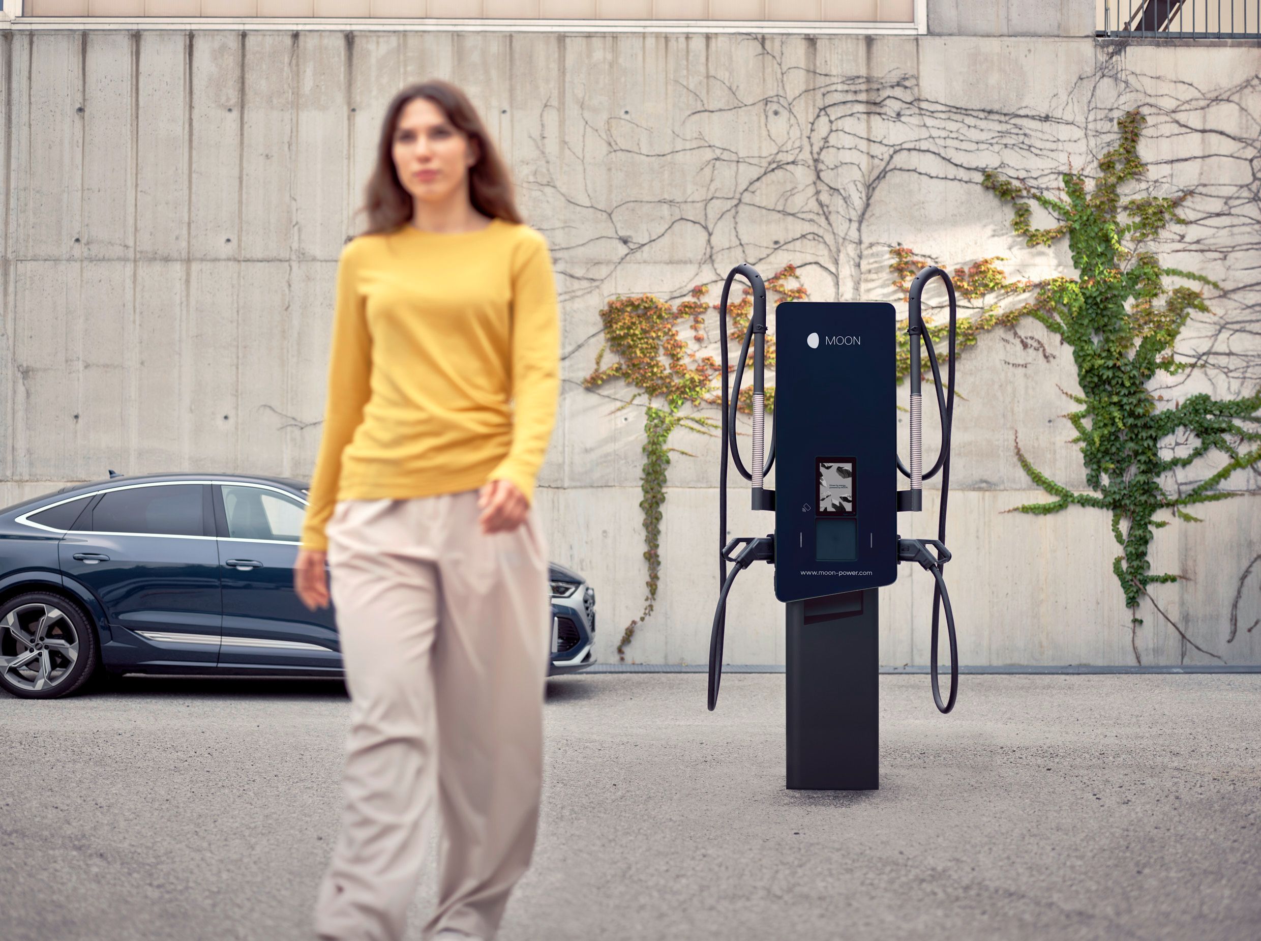 Žena odlazi od stanice za punjenje ispred automobila