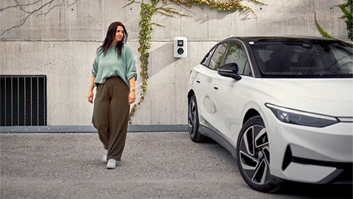 Žena hoda pokraj auta prema kameri