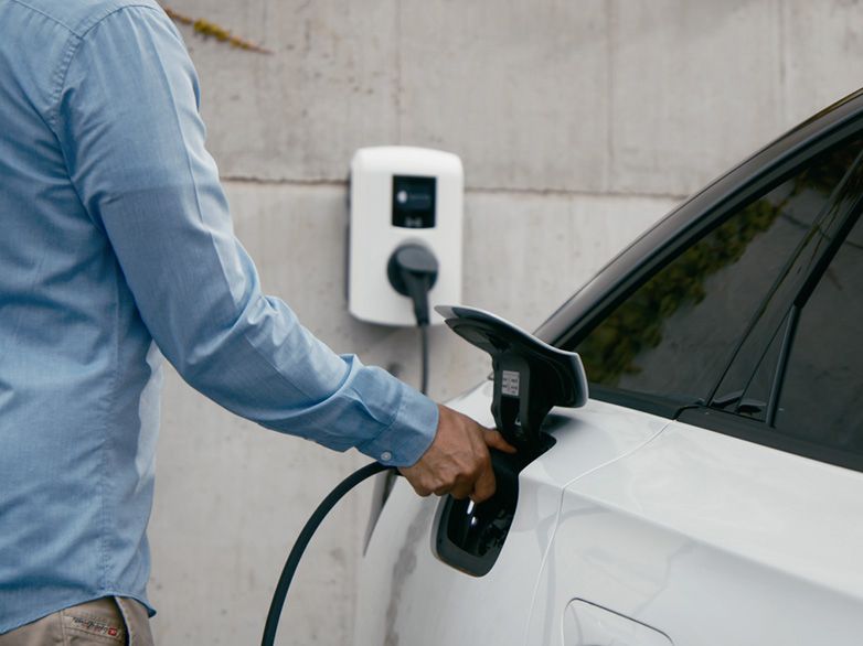 Osoba koja puni automobil na zidnoj kutiji