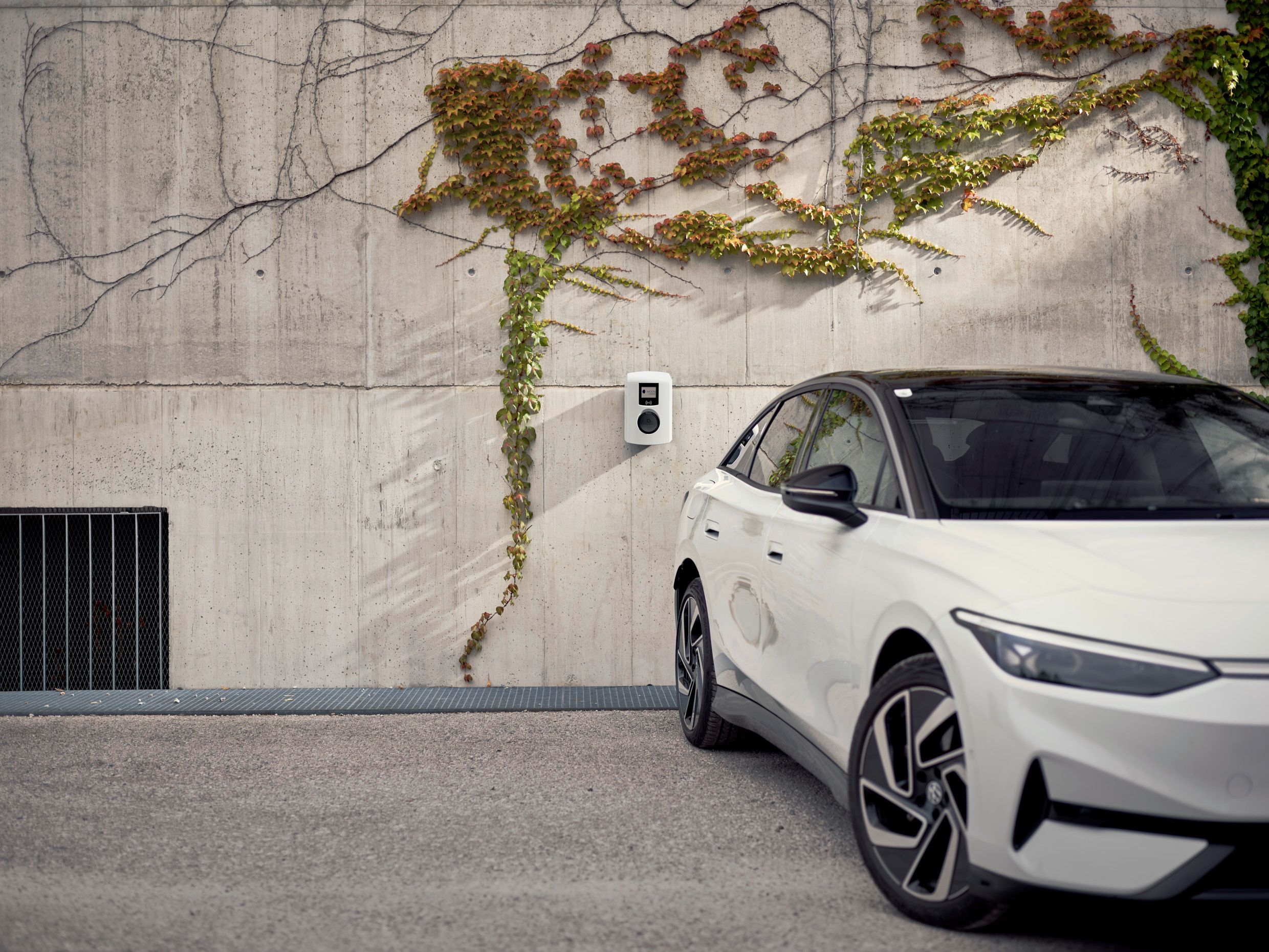 Auto stoji ispred betonskog zida s zidnom kutijom