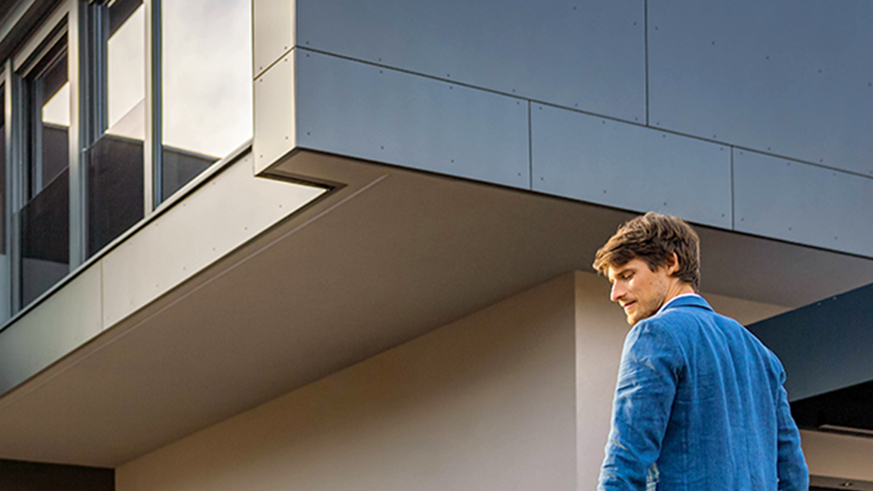 Osoba hoda prema automobilu s kabelom u ruci