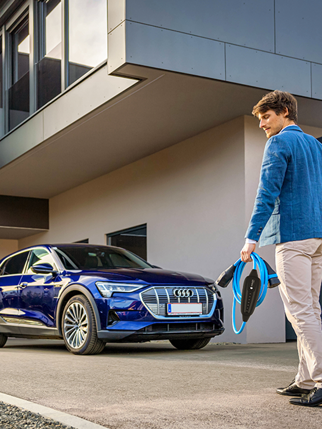 Osoba hoda prema automobilu s kabelom u ruci